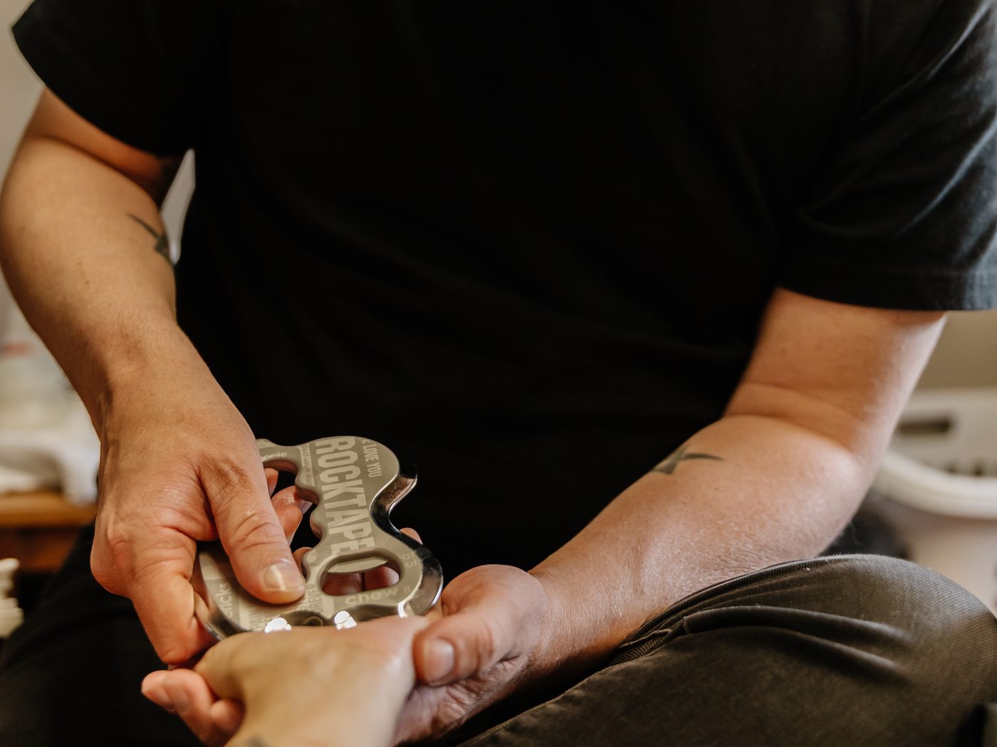 IASTM, stainless steel instrument applied to the forearm.