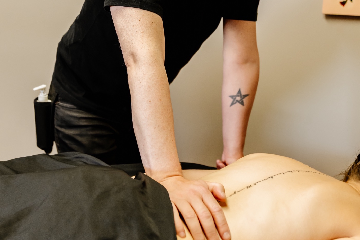 Mathieu Boudreau, RMT, applying controlled pressure with both hands during an upper-back massage treatment in his Moncton clinic.