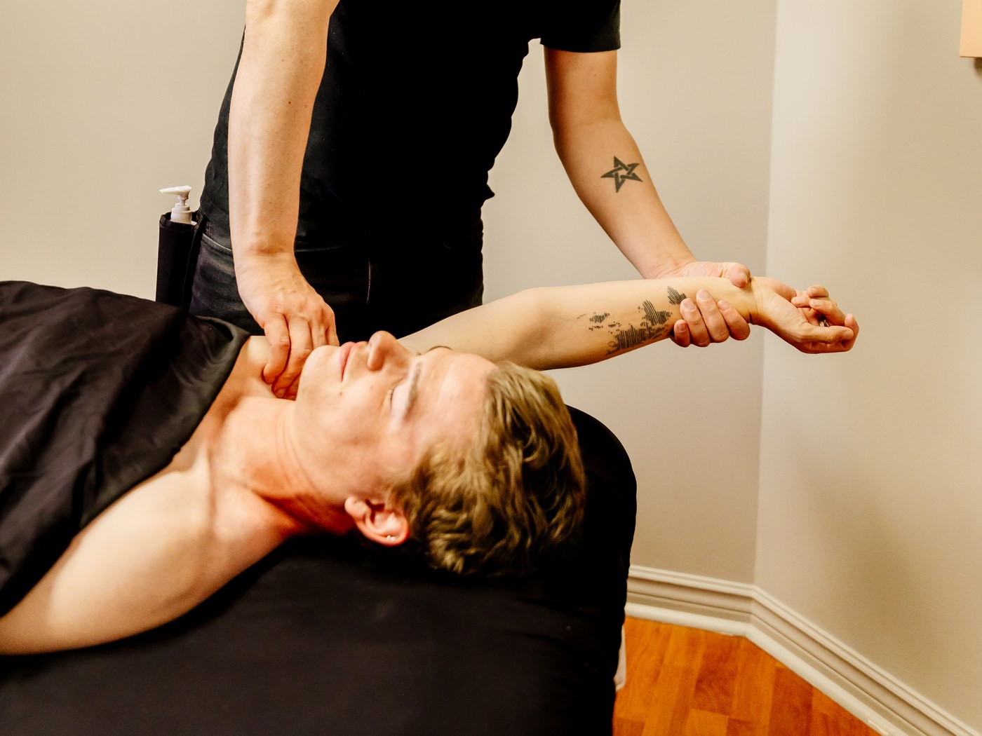 Mathieu guides a client's arm overhead while applying shoulder contact during RAPID NeuroFascial Reset.